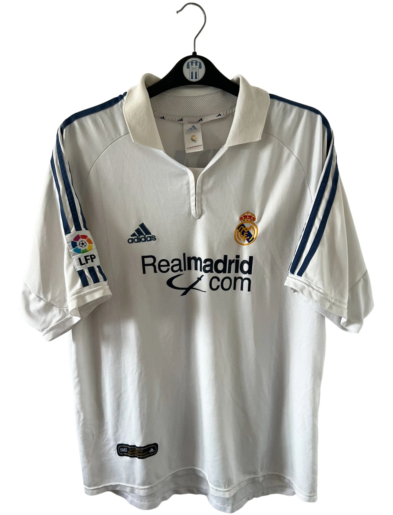 Maillot de foot vintage domicile blanc du Real Madrid de la saison 2001/2002. On peut retrouver l'équipementier Adidas et le sponsor Real Madrid.com. Le maillot est floqué du numéro 5 Zinedine Zidane. Il s'agit d'un maillot authentique d'époque.