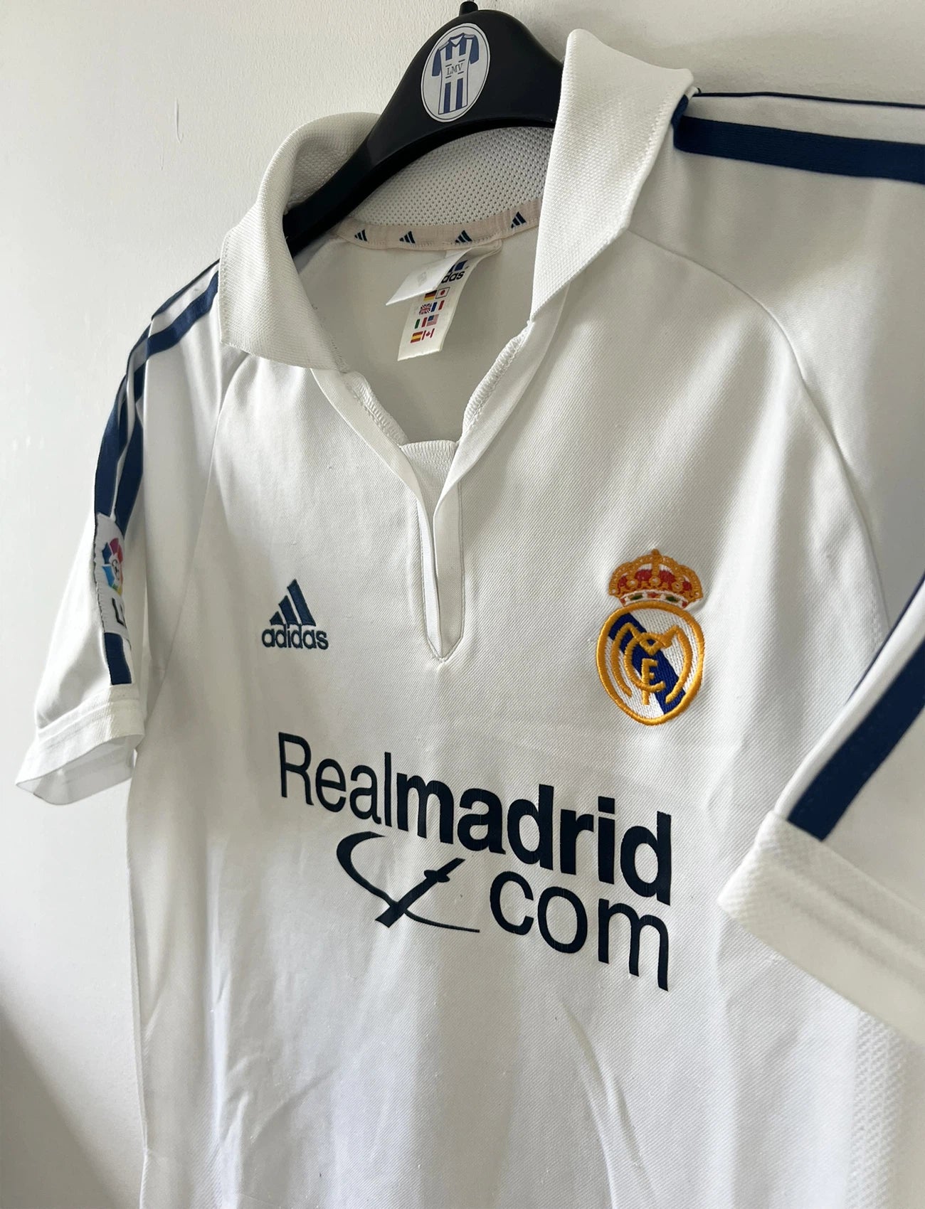 Maillot de foot vintage domicile blanc du real madrid de la saison 2001/2002. On peut retrouver l'équipementier Adidas et le sponsor Rea Madrid. Le maillot est floqué du numéro 5 Zinedine Zidane. Il s'agit d'un maillot authentique d'époque.