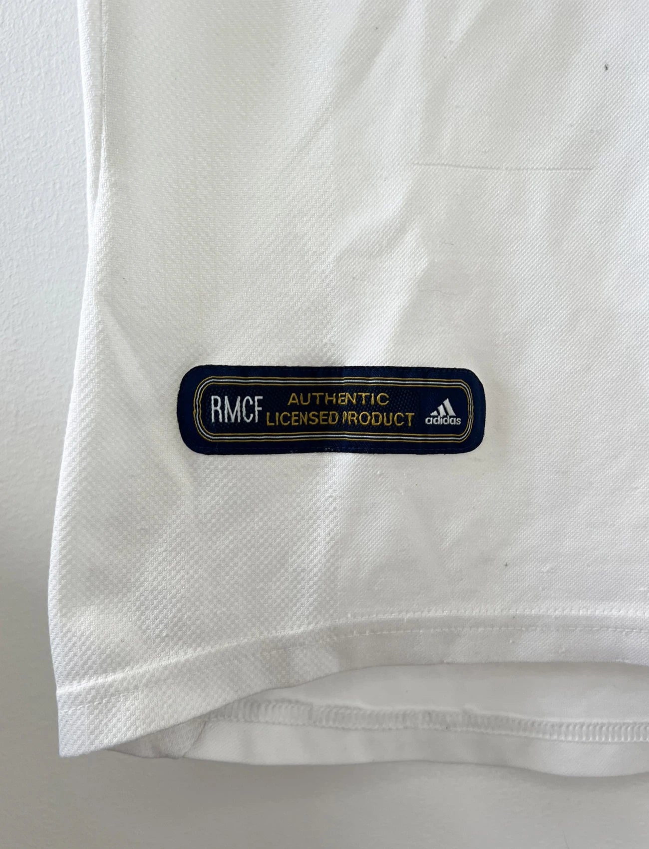 Maillot de foot vintage domicile blanc du real madrid de la saison 2001/2002. On peut retrouver l'équipementier Adidas et le sponsor Rea Madrid. Le maillot est floqué du numéro 5 Zinedine Zidane. Il s'agit d'un maillot authentique d'époque.