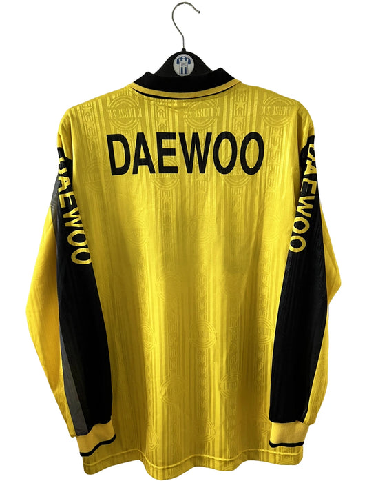 Maillot de foot vintage domicile jaune et noir du SK Lierse saison 1997/1998. On peut retrouver l'équipementier Lotto et le sponsor Daewoo. Il s'agit d'un maillot authentique d'époque.
