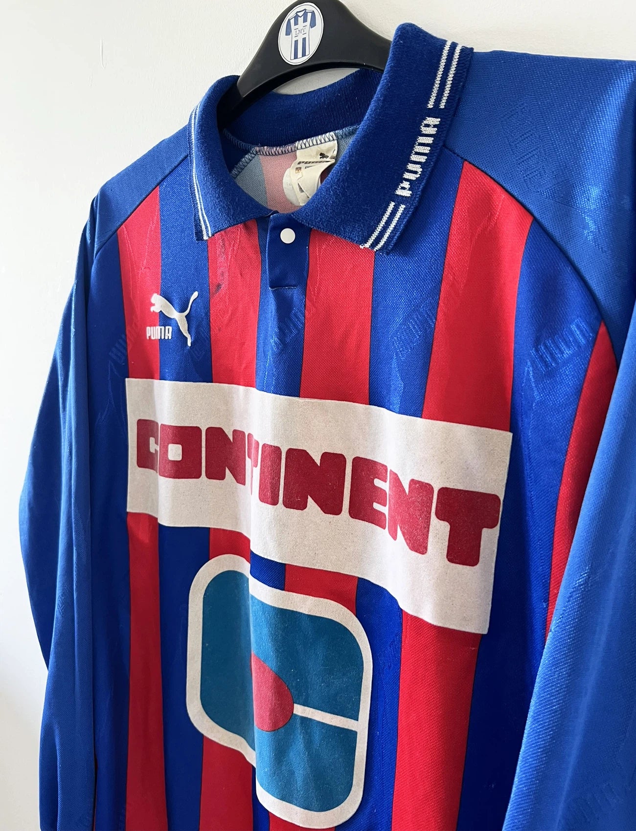 Maillot de foot vintage domicile rouge et bleu du SM Caen de la saison 1994/1995. On peut retrouver l'équipementier Puma et le sponsor Continent. Le maillot est floqué du numéro 9 Kennet Andersson. Il s'agit d'un maillot authentique d'époque.