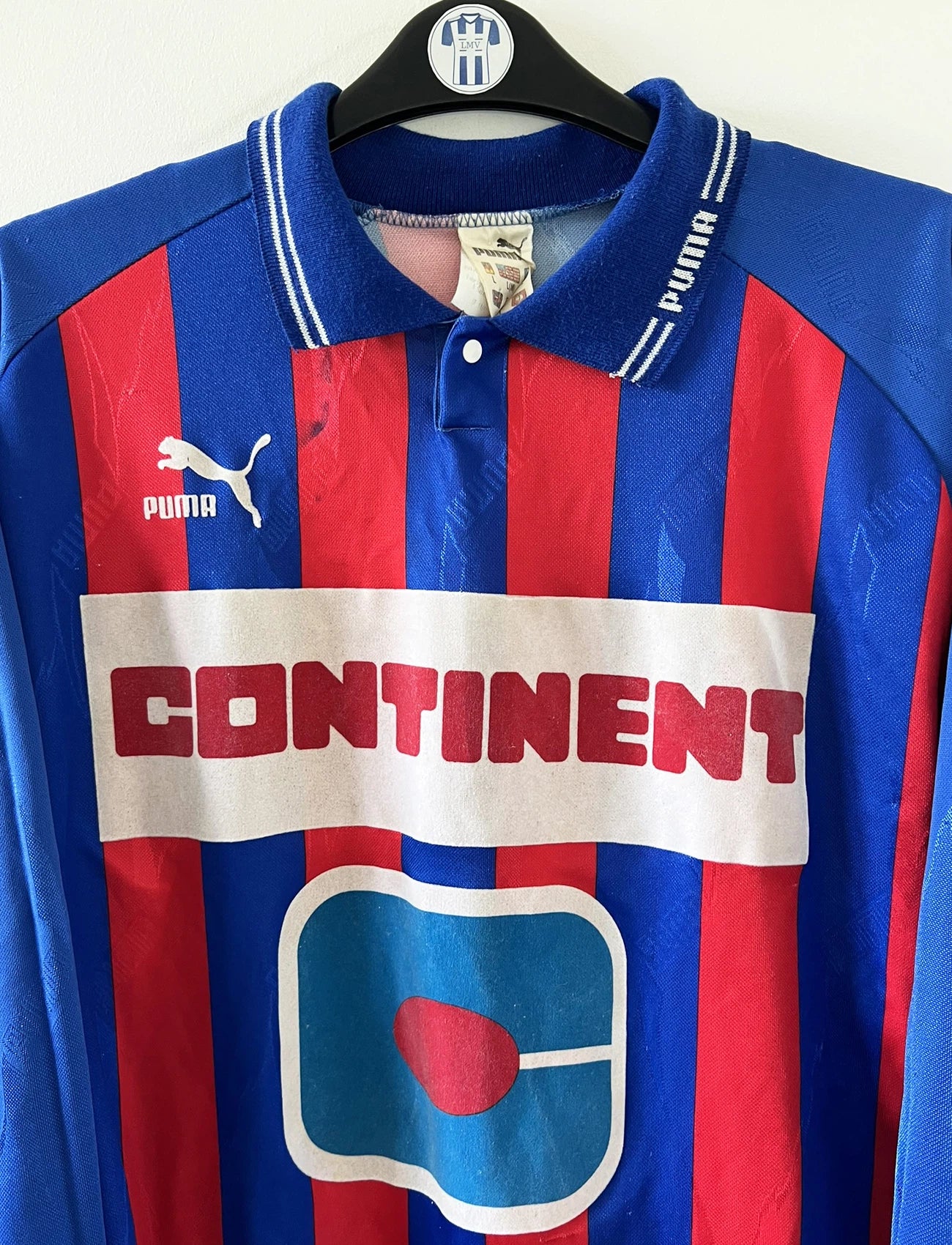 Maillot de foot vintage domicile rouge et bleu du SM Caen de la saison 1994/1995. On peut retrouver l'équipementier Puma et le sponsor Continent. Le maillot est floqué du numéro 9 Kennet Andersson. Il s'agit d'un maillot authentique d'époque.