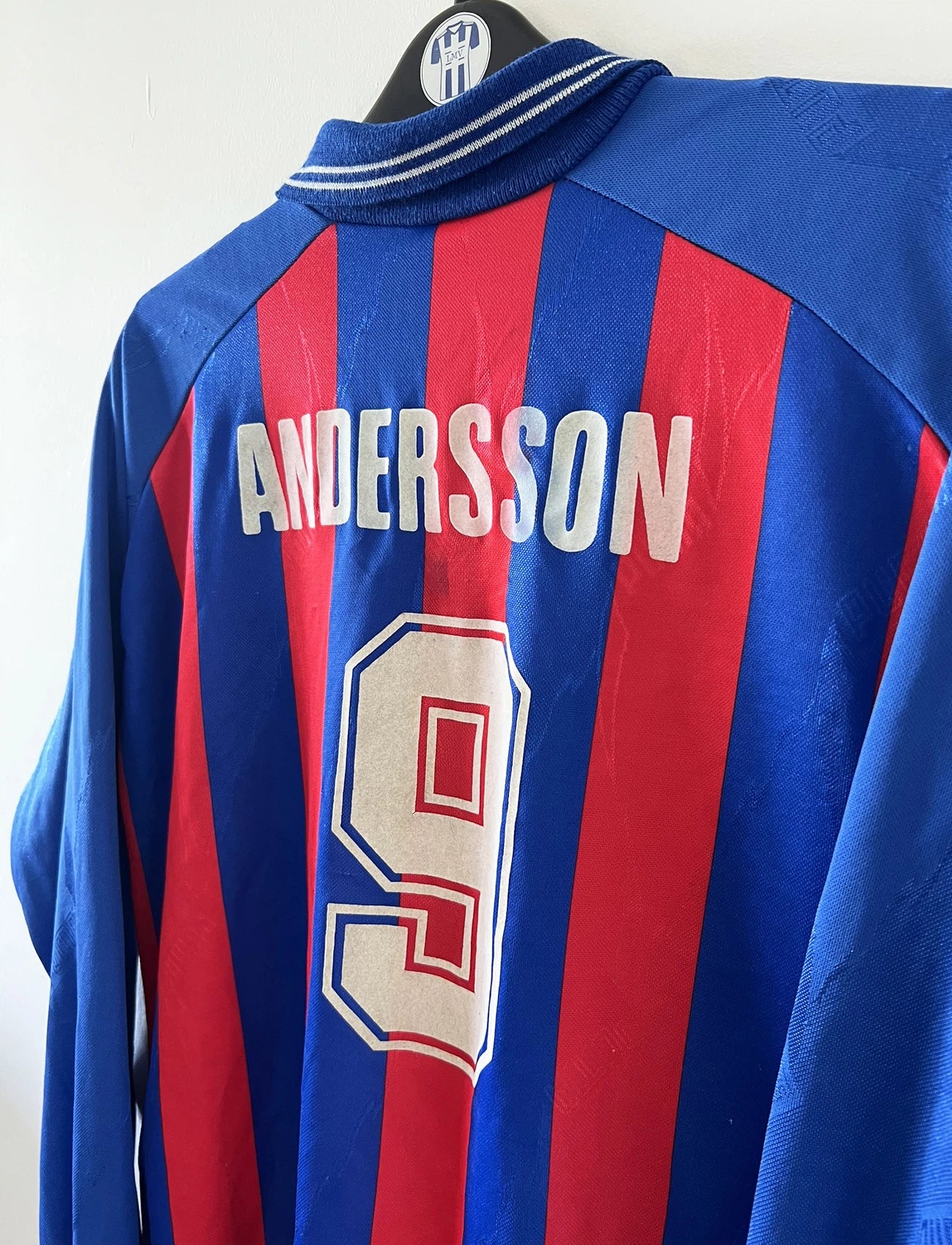 Maillot de foot vintage domicile rouge et bleu du SM Caen de la saison 1994/1995. On peut retrouver l'équipementier Puma et le sponsor Continent. Le maillot est floqué du numéro 9 Kennet Andersson. Il s'agit d'un maillot authentique d'époque.