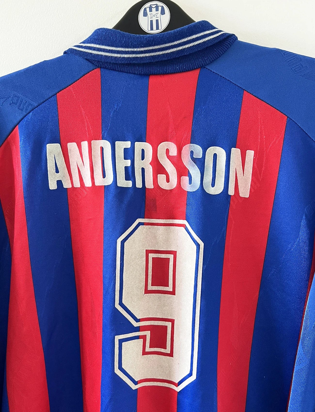Maillot de foot vintage domicile rouge et bleu du SM Caen de la saison 1994/1995. On peut retrouver l'équipementier Puma et le sponsor Continent. Le maillot est floqué du numéro 9 Kennet Andersson. Il s'agit d'un maillot authentique d'époque.