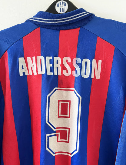 Maillot de foot vintage domicile rouge et bleu du SM Caen de la saison 1994/1995. On peut retrouver l'équipementier Puma et le sponsor Continent. Le maillot est floqué du numéro 9 Kennet Andersson. Il s'agit d'un maillot authentique d'époque.