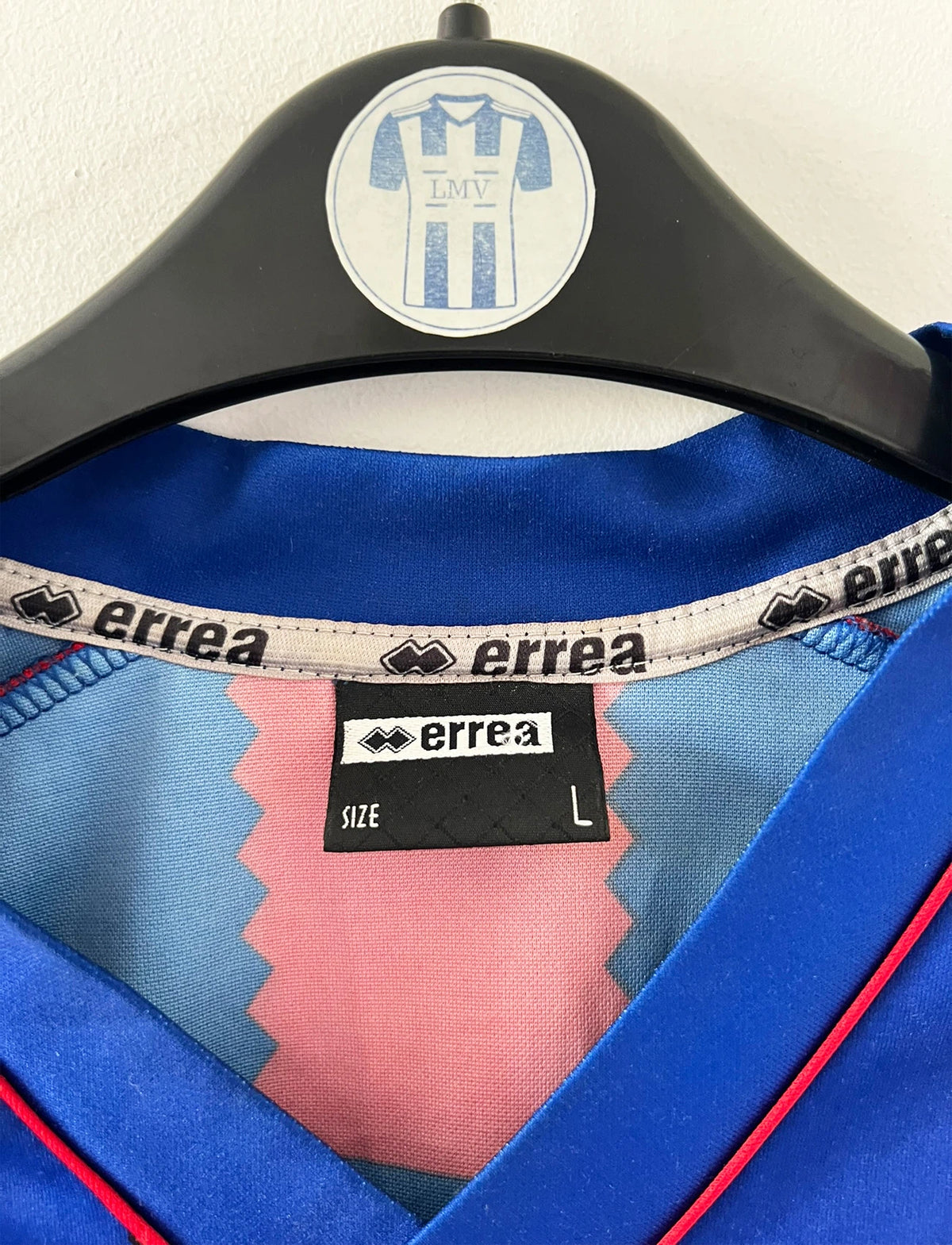 Maillot de foot vintage rouge et bleu du SM Caen de la saison 2004/2005. Il s'agit du maillot édité pour la finale de la Coupe de la Ligue. On peut retrouver les sponsors Isigny Ste Mère et Brittany Ferries. Il s'agit d'un maillot authentique d'époque.