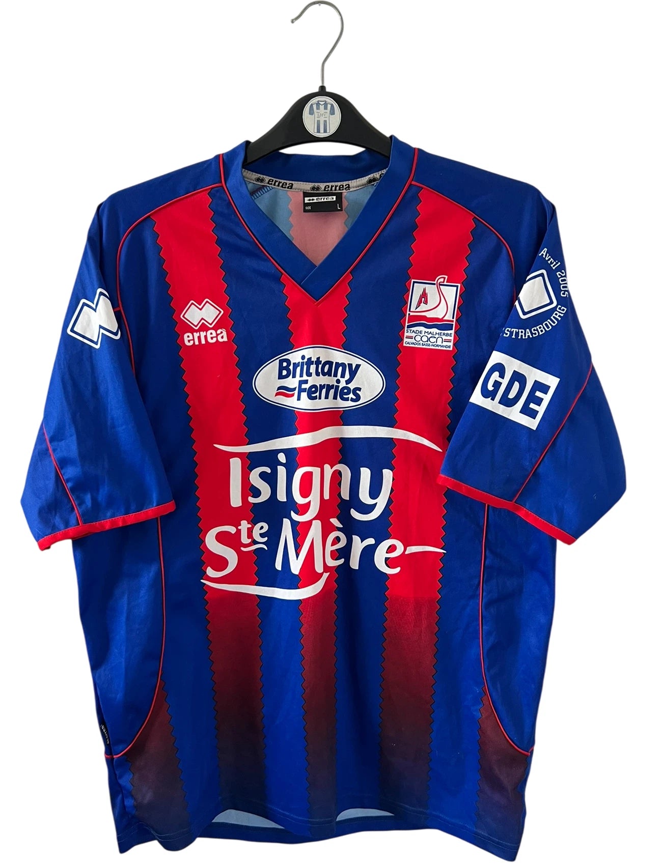 Maillot de foot vintage rouge et bleu du SM Caen de la saison 2004/2005. Il s'agit du maillot édité pour la finale de la Coupe de la Ligue. On peut retrouver les sponsors Isigny Ste Mère et Brittany Ferries. Il s'agit d'un maillot authentique d'époque.