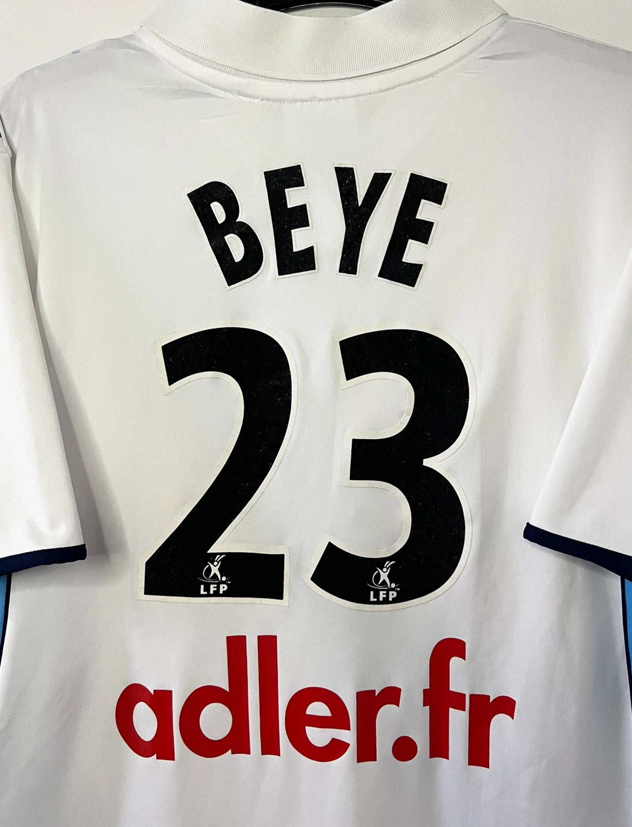 Maillot de foot vintage extérieur blanc du Racing Club de Strasbourg de la saison 2001/2003. On peut retrouver l'équipementier Asics et le sponsor Adler. Il s'agit d'un maillot authentique d'époque.