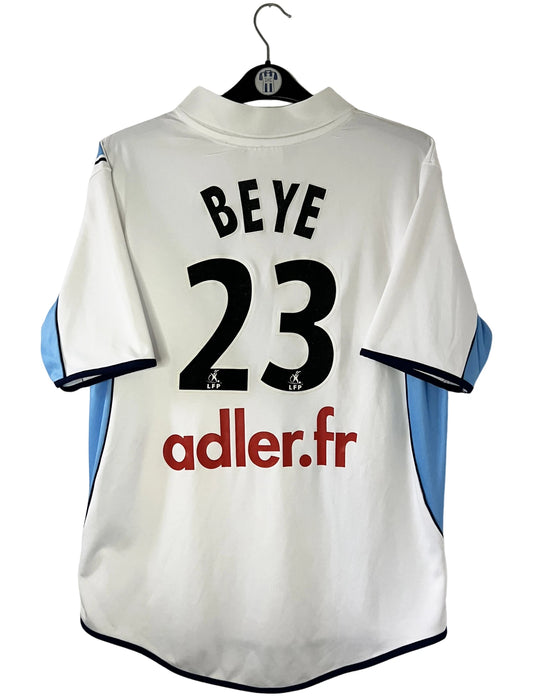 Maillot de foot vintage extérieur blanc du Racing Club de Strasbourg de la saison 2001/2003. On peut retrouver l'équipementier Asics et le sponsor Adler. Il s'agit d'un maillot authentique d'époque.