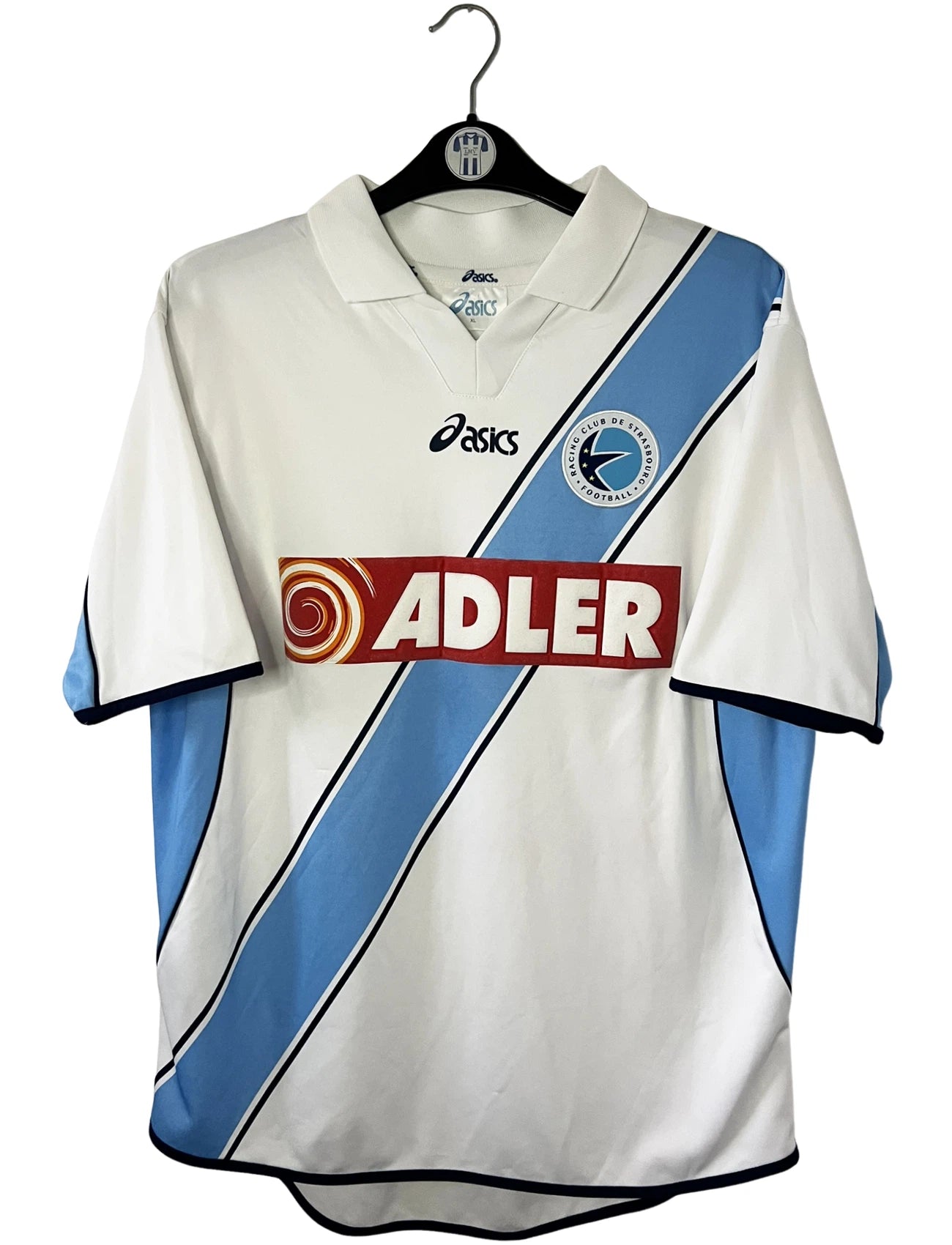 Maillot de foot vintage extérieur blanc du Racing Club de Strasbourg de la saison 2001/2003. On peut retrouver l'équipementier Asics et le sponsor Adler. Il s'agit d'un maillot authentique d'époque.