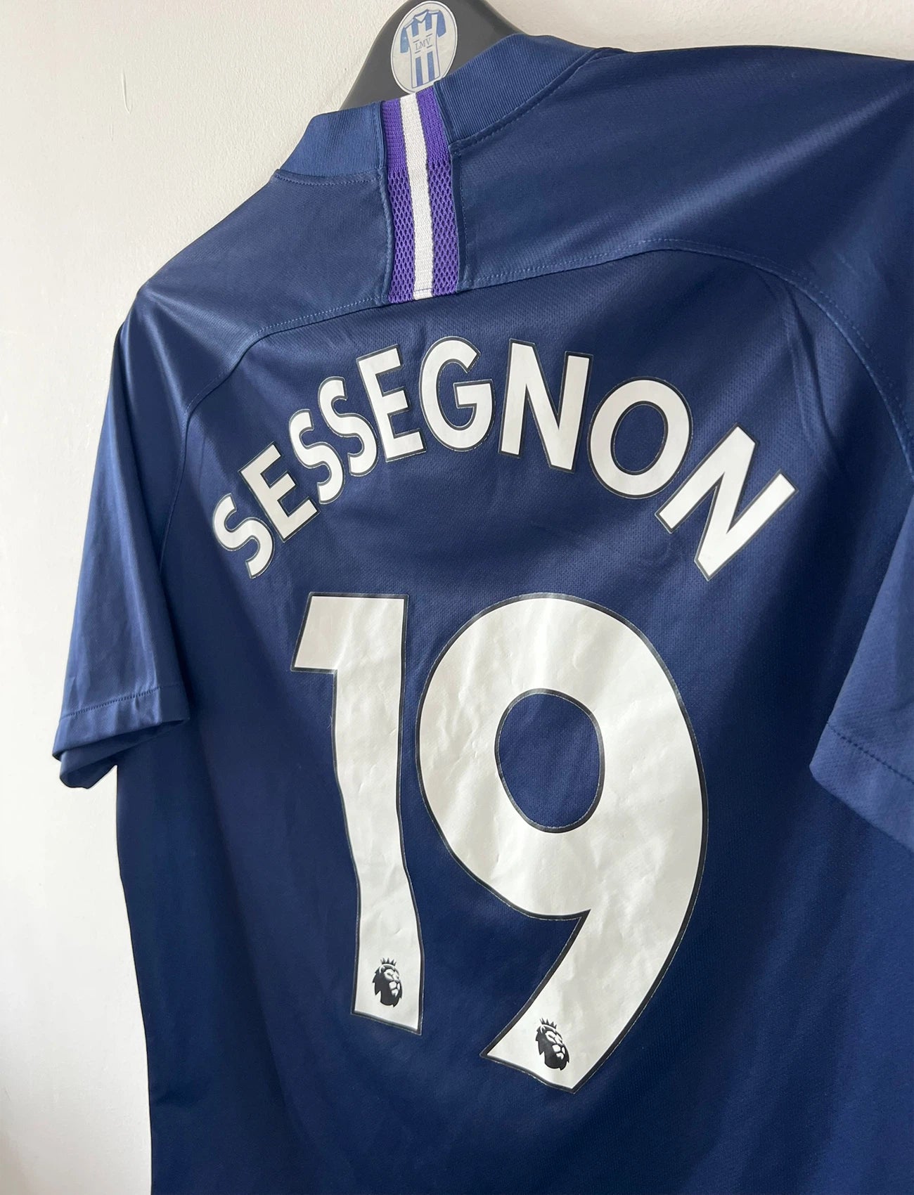 Maillot de foot vintage bleu domicile de Tottenham saison 2019/2020. On peut retrouver l'équipementier Nike et le sponsor AIA. Le maillot est floqué du numéro 19 Ryan Sessegnon. Il s'agit d'un maillot authentique d'époque.
