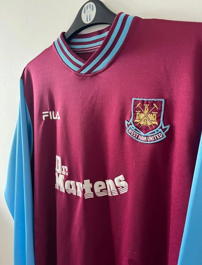 Maillot de foot vintage domicile rouge et bleu de West Ham 2001/2003. On peut retrouver l'équipementier Fila et le sponsor Dr Martens. Il s'agit d'un maillot authentique d'époque.