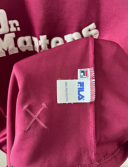 Maillot de foot vintage domicile rouge et bleu de West Ham 2001/2003. On peut retrouver l'équipementier Fila et le sponsor Dr Martens. Il s'agit d'un maillot authentique d'époque.