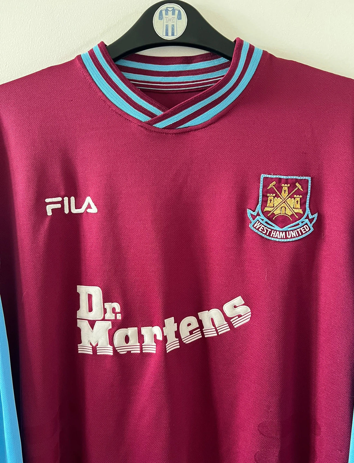 Maillot de foot vintage domicile rouge et bleu de West Ham 2001/2003. On peut retrouver l'équipementier Fila et le sponsor Dr Martens. Il s'agit d'un maillot authentique d'époque.
