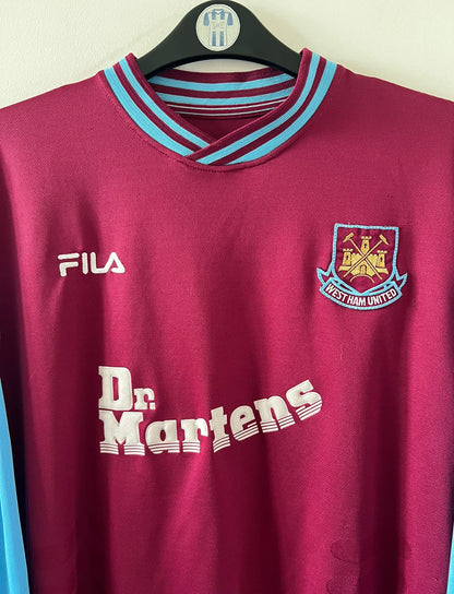 Maillot de foot vintage domicile rouge et bleu de West Ham 2001/2003. On peut retrouver l'équipementier Fila et le sponsor Dr Martens. Il s'agit d'un maillot authentique d'époque.