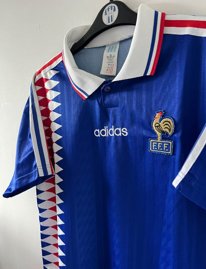 Maillot de foot vintage domicile bleu de l'Equipe de France 1994. On peut retrouver l'équipementier Adidas. Il s'agit d'un maillot authentique d'époque.