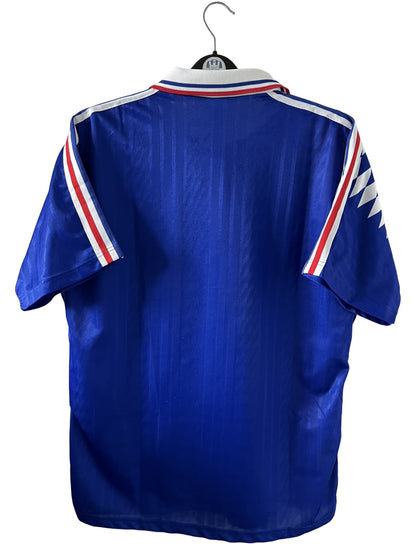 Maillot de foot vintage domicile bleu de l'Equipe de France 1994. On peut retrouver l'équipementier Adidas. Il s'agit d'un maillot authentique d'époque.