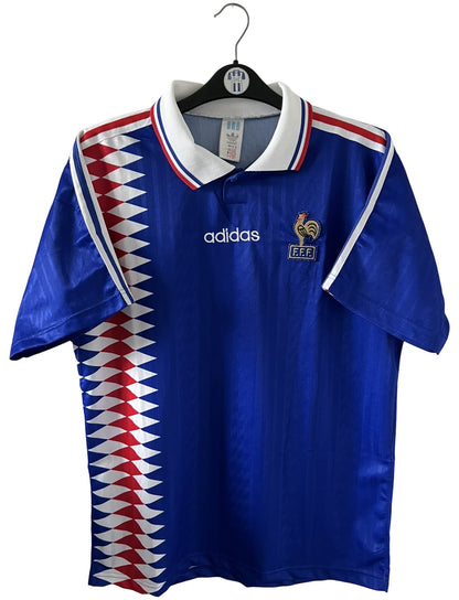 Maillot de foot vintage domicile bleu de l'Equipe de France 1994. On peut retrouver l'équipementier Adidas. Il s'agit d'un maillot authentique d'époque.