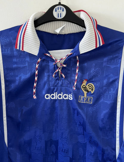 Maillot de foot vintage domicile bleu blanc et rouge de l'équipe de france 1996. On peut retrouver l'équipementier adidas. Il s'agit d'un maillot authentique d'époque