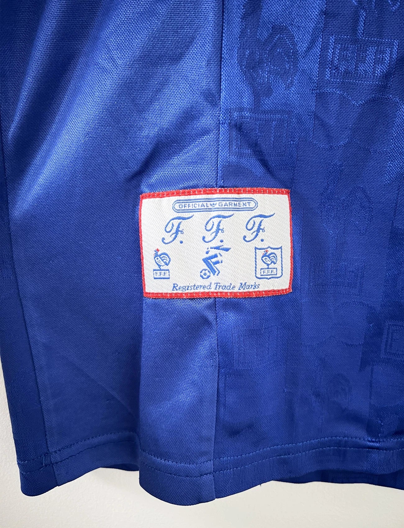Maillot de foot vintage domicile de l'équipe de france 1996 de couleur bleu blanc et rouge. On peut retrouver l'équipementier adidas et le coq sans étoile. Il s'agit d'un maillot authentique d'époque.