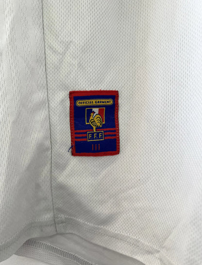 Maillot de foot vintage extérieur blanc de l'Equipe de France 1998. On peut retrouver l'équipementier Adidas. Il s'agit d'un maillot authentique d'époque.
