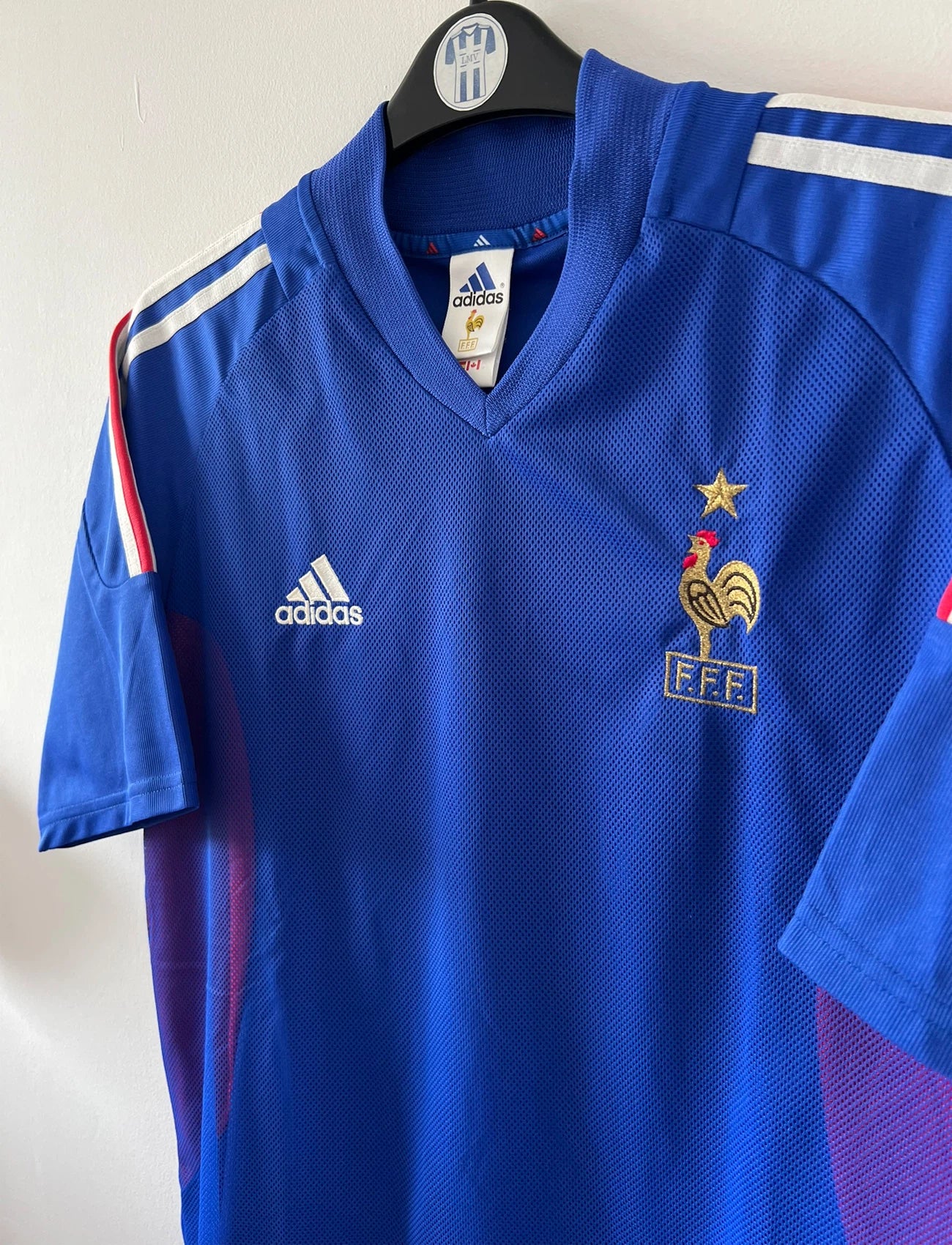 Maillot de foot vintage domicile bleu de l'équipe de france 2002. On peut retrouver l'équipementier Adidas. Le maillot est floqué du numéro 10 Zidane. Il s'agit d'un maillot authentique d'époque.