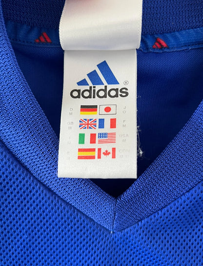 Maillot de foot vintage domicile bleu de l'équipe de france 2002. On peut retrouver l'équipementier Adidas. Le maillot est floqué du numéro 10 Zidane. Il s'agit d'un maillot authentique d'époque.