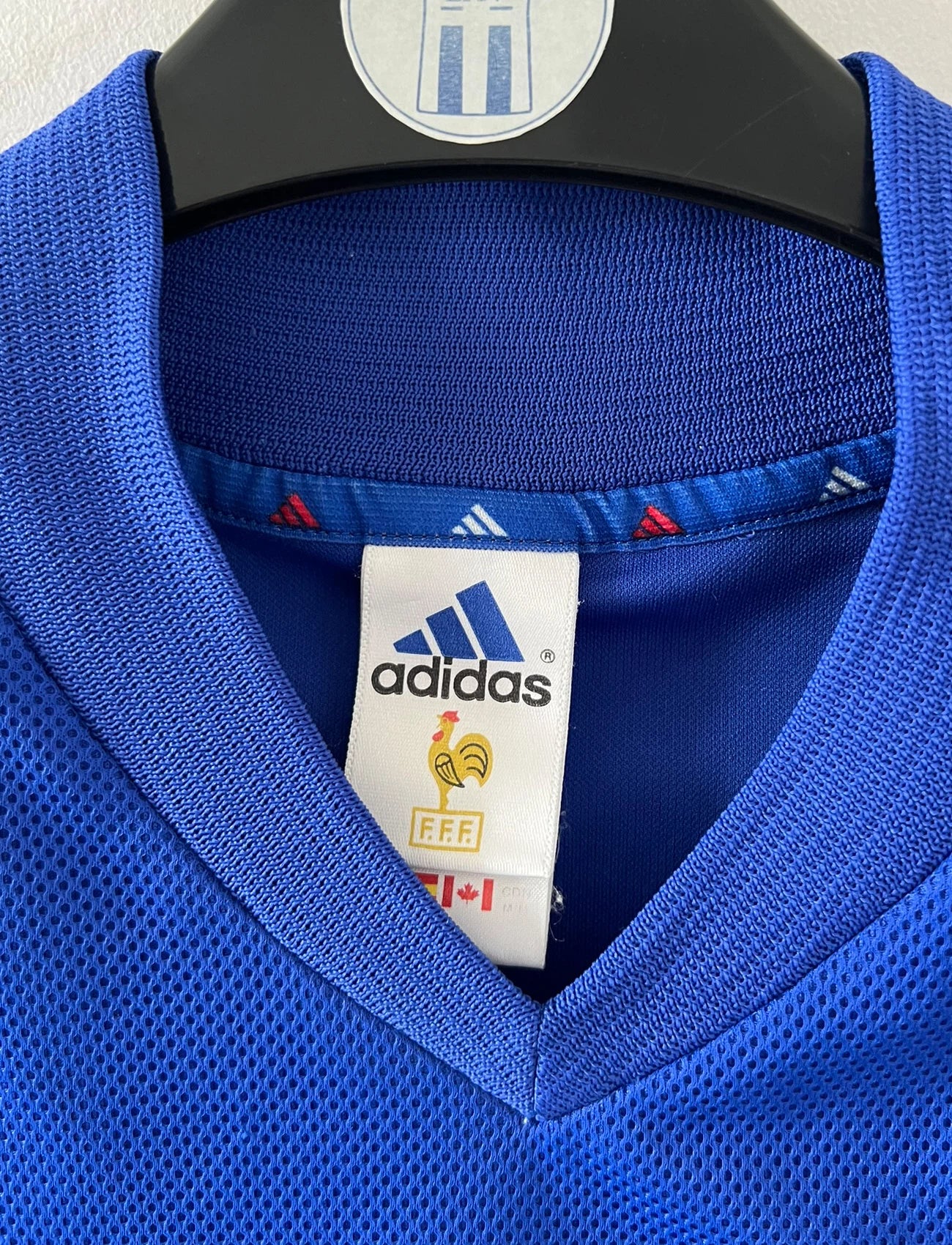 Maillot de foot vintage domicile bleu de l'équipe de france 2002. On peut retrouver l'équipementier Adidas. Le maillot est floqué du numéro 10 Zidane. Il s'agit d'un maillot authentique d'époque.