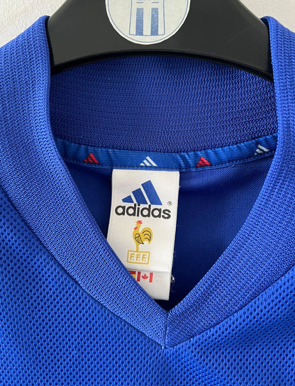 Maillot de foot vintage domicile bleu de l'équipe de france 2002. On peut retrouver l'équipementier Adidas. Le maillot est floqué du numéro 10 Zidane. Il s'agit d'un maillot authentique d'époque.