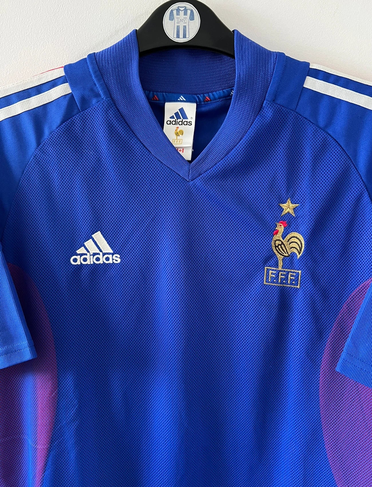 Maillot de foot vintage domicile bleu de l'équipe de france 2002. On peut retrouver l'équipementier Adidas. Le maillot est floqué du numéro 10 Zidane. Il s'agit d'un maillot authentique d'époque.