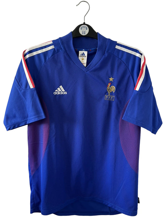 Maillot de foot vintage domicile bleu de l'équipe de france 2002. On peut retrouver l'équipementier Adidas. Le maillot est floqué du numéro 10 Zidane. Il s'agit d'un maillot authentique d'époque.