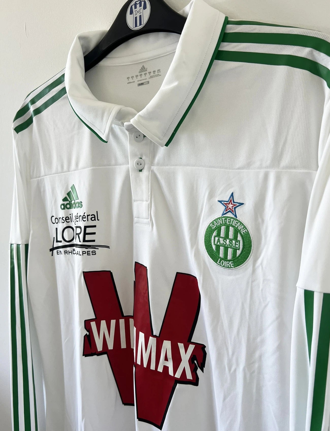 Maillot de foot vintage extérieur blanc et vert de l'ASSE de l'année 2010/2011. On peut retrouver l'équipementier adidas et le sponsor Winamax. Il s'agit d'un maillot authentique d'époque comportant les numéros U40897