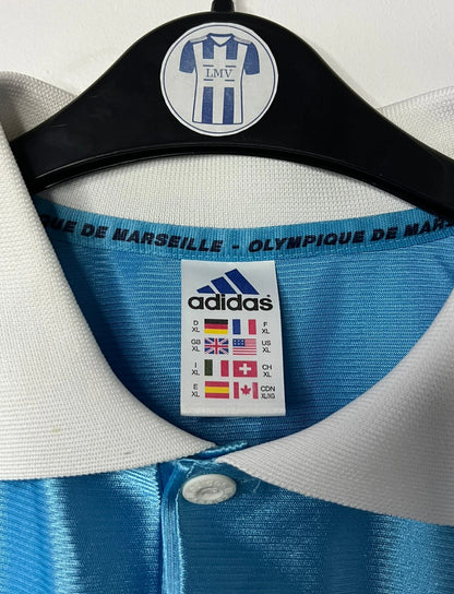 Maillot de foot vintage extérieur bleu de l'OM saison 1998/1999. On peut retrouver l'équipementier Adidas et le sponsor Ericsson. Il s'agit d'un maillot authentique d'époque.