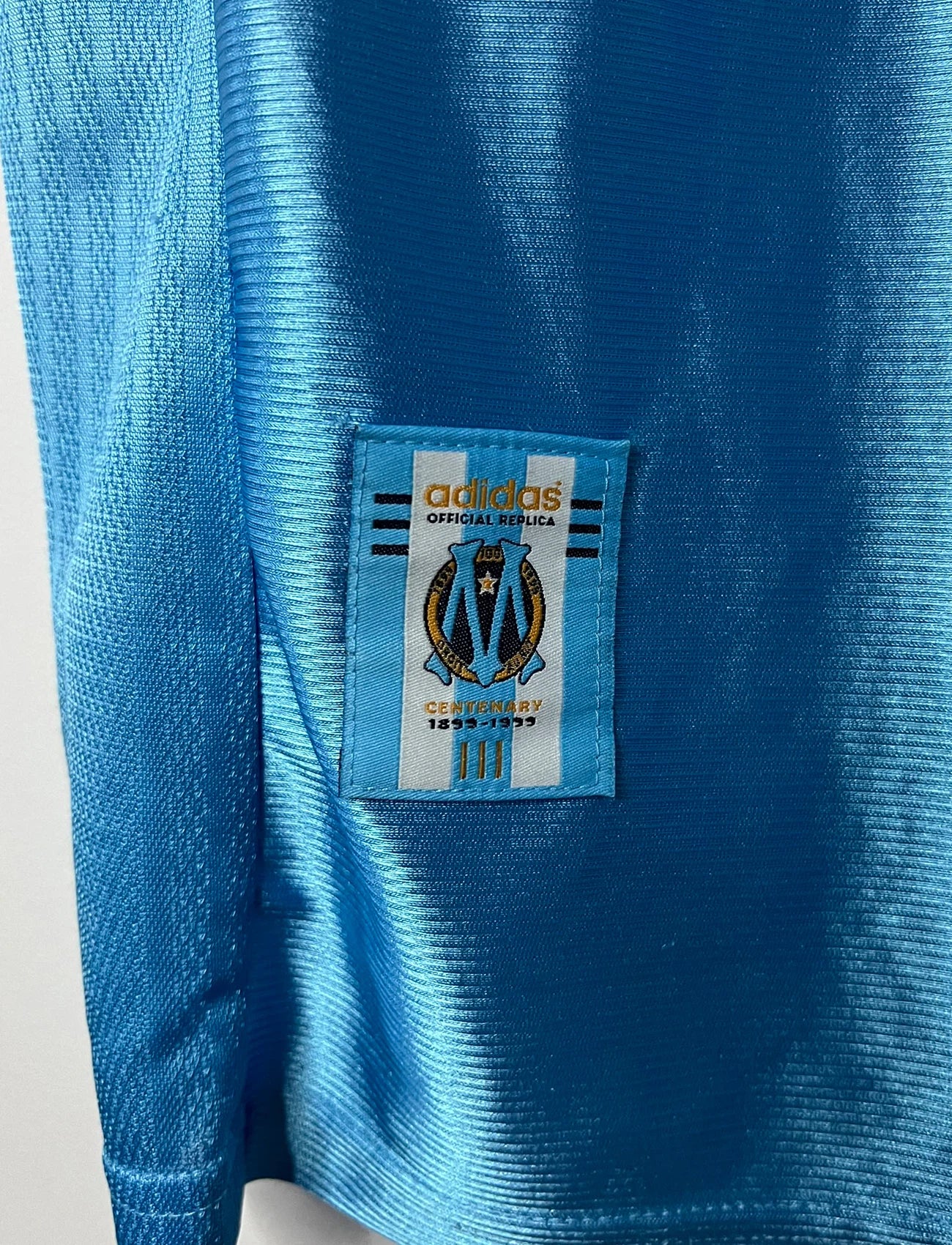 Maillot de foot vintage extérieur bleu de l'OM saison 1998/1999. On peut retrouver l'équipementier Adidas et le sponsor Ericsson. Il s'agit d'un maillot authentique d'époque.