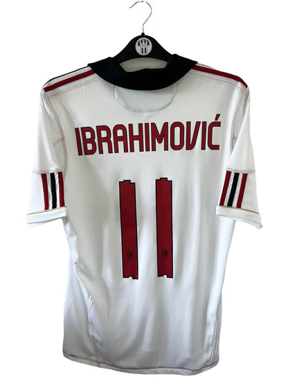 Maillot de foot vintage extérieur de l'AC Milan couleur blanc de la saison 2010/2011. On peut retrouver l'équipementier adidas et le sponsor Fly Emirates. Le maillot est floqué du numéro 11 Zlatan Ibrahimovic. Il s'agit d'un maillot authentique d'époque comportant les numéros P96277