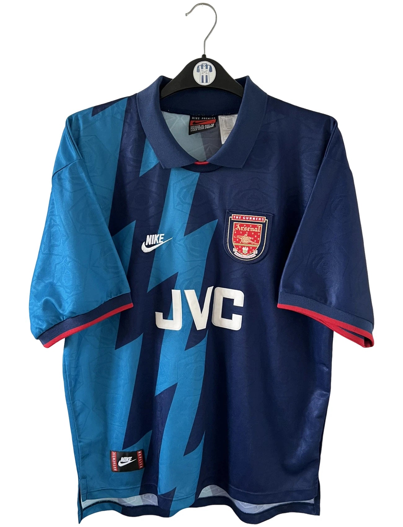 Maillot de foot vintage extérieur bleu d'arsenal de la saison 1995/1996. On peut retrouver l'équipementier Nike et le sponsor JVC. Il s'agit d'un maillot authentique d'époque.