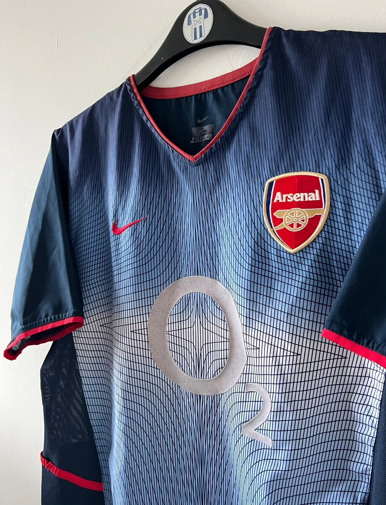 Maillot foot vintage extérieur bleu d'arsenal de la saison 2002/2003. On peut retrouver l'équipementier Nike et le sponsor O2. Le maillot est floqué du numéro 14 Thierry Henry. Il s'agit d'un maillot authentique d'époque. 