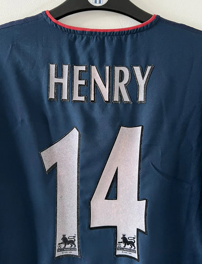 Maillot foot vintage extérieur bleu d'arsenal de la saison 2002/2003. On peut retrouver l'équipementier Nike et le sponsor O2. Le maillot est floqué du numéro 14 Thierry Henry. Il s'agit d'un maillot authentique d'époque. 