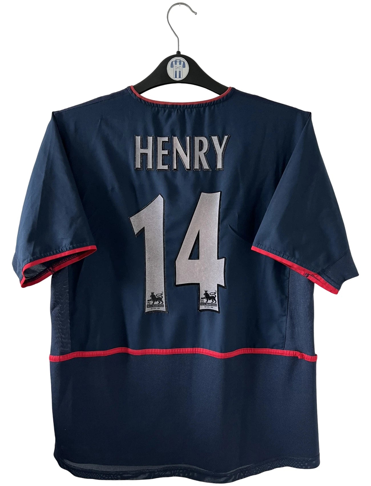 Maillot foot vintage extérieur bleu d'arsenal de la saison 2002/2003. On peut retrouver l'équipementier Nike et le sponsor O2. Le maillot est floqué du numéro 14 Thierry Henry. Il s'agit d'un maillot authentique d'époque. 
