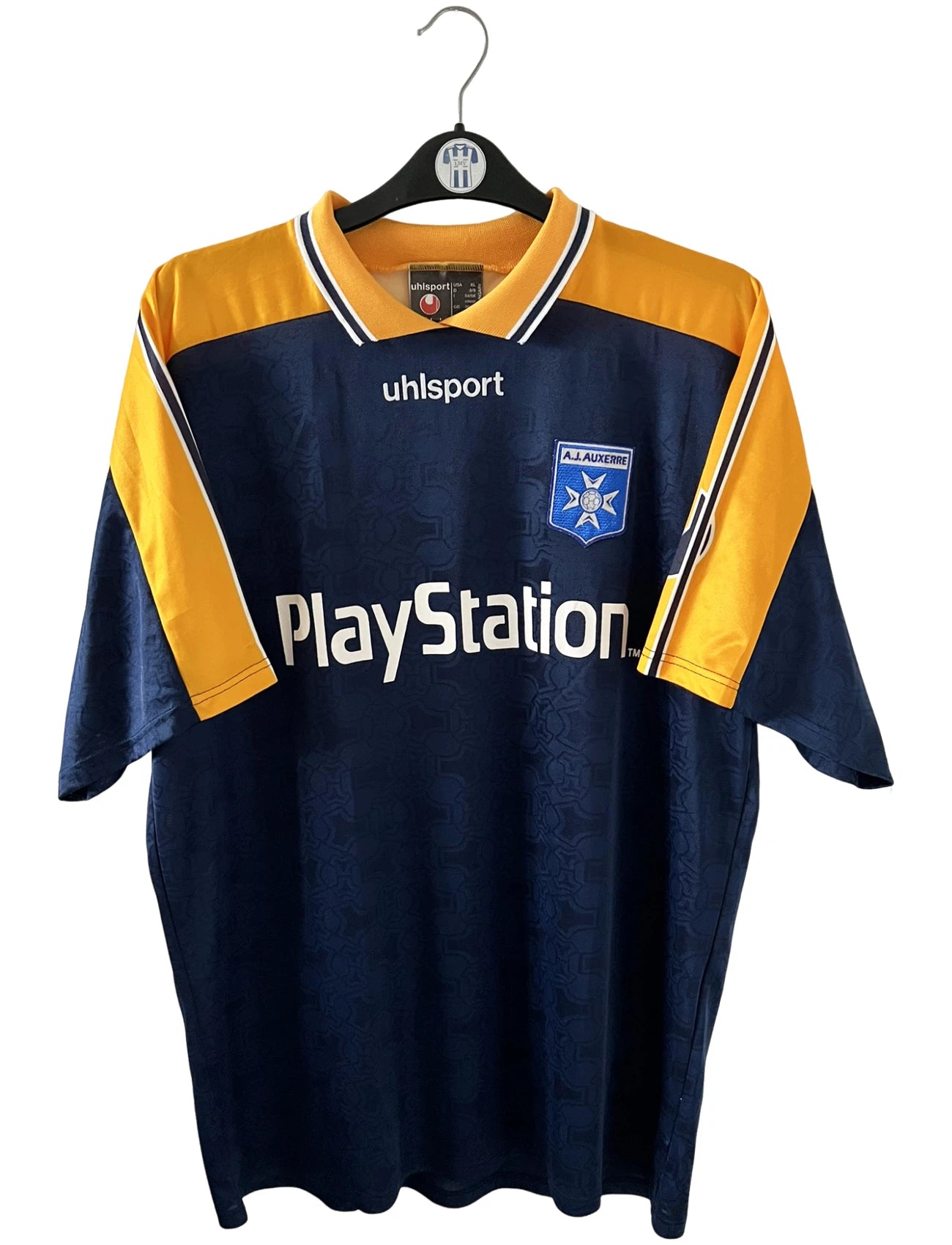 Maillot de foot vintage extérieur jaune et bleu de l'AJ Auxerre 2000/2001. On peut retrouver l'équipementier Uhlsport et le sponsor Playstation. Il s'agit d'un maillot authentique d'époque.