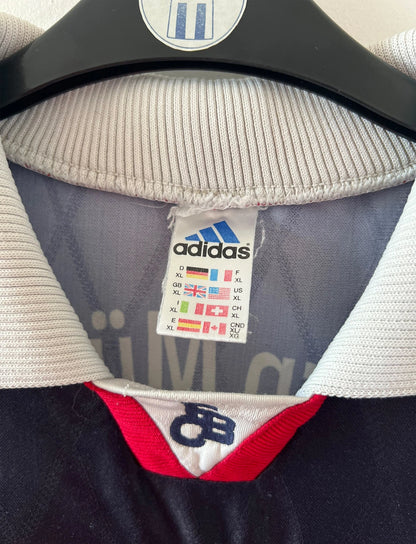 Maillot de foot vintage extérieur noir du Bayern Munich 1997/1998. On peut retrouver l'équipementier Adidas et le sponsor Opel. Le maillot est accompagné de son short d'époque. Il s'agit d'un maillot et d'un short authentique.