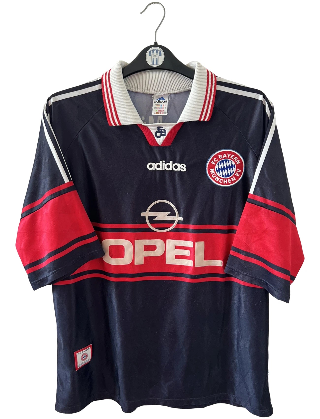 Maillot de foot vintage extérieur noir du Bayern Munich 1997/1998. On peut retrouver l'équipementier Adidas et le sponsor Opel. Le maillot est accompagné de son short d'époque. Il s'agit d'un maillot et d'un short authentique.