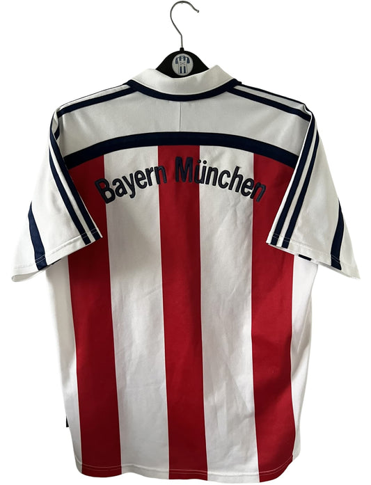 Maillot de foot vintage extérieur blanc du Bayern Munich de la saison 2000/2002. On peut retrouver l'équipementier Adidas et le sponsor Opel. Il s'agit d'un maillot authentique d'époque.