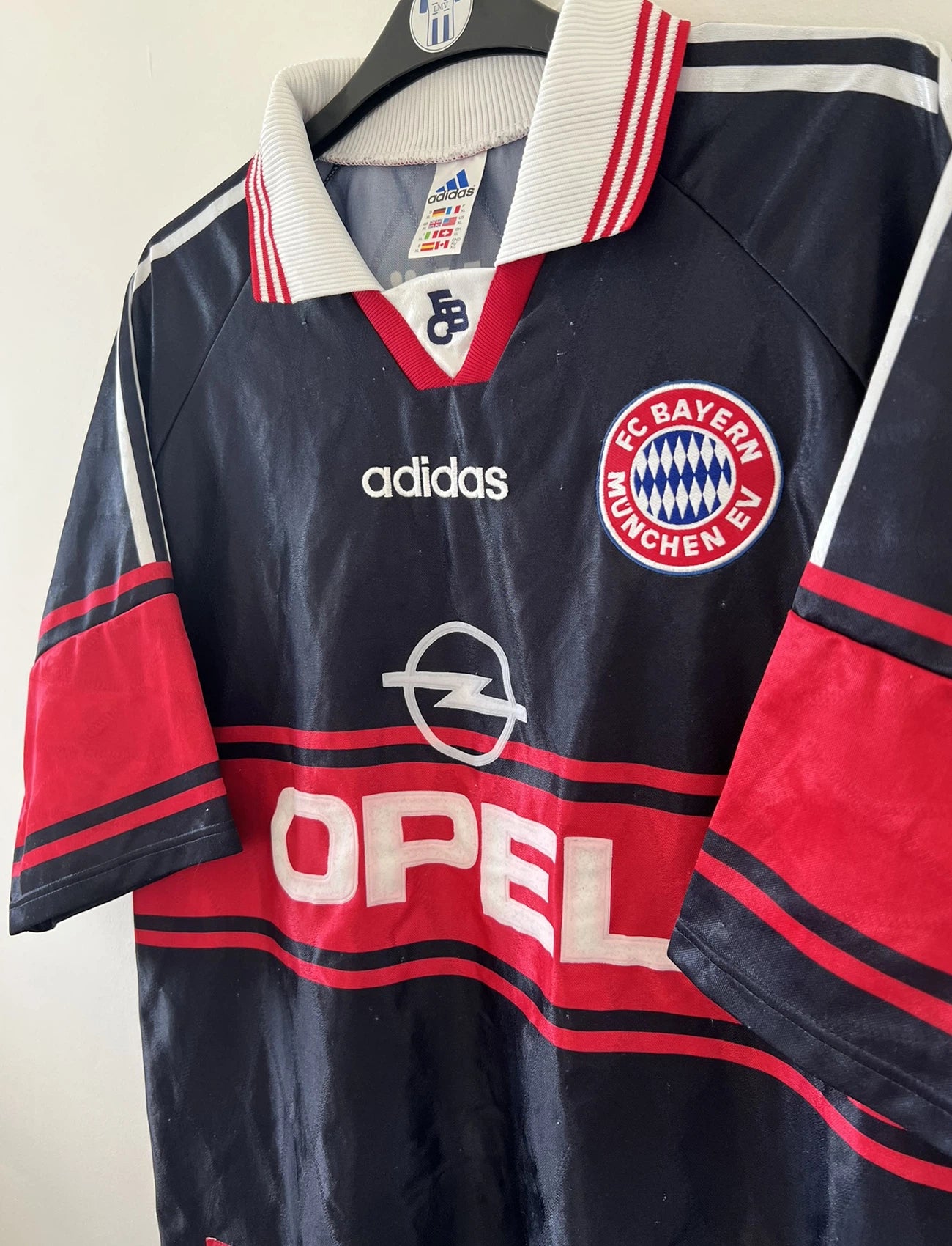 Maillot de foot vintage domicile noir et rouge du bayern munich de la saison 1997/1998. On peut retrouver l'équipementier adidas et le sponsor Opel. Il s'agit d'un maillot authentique d'époque.