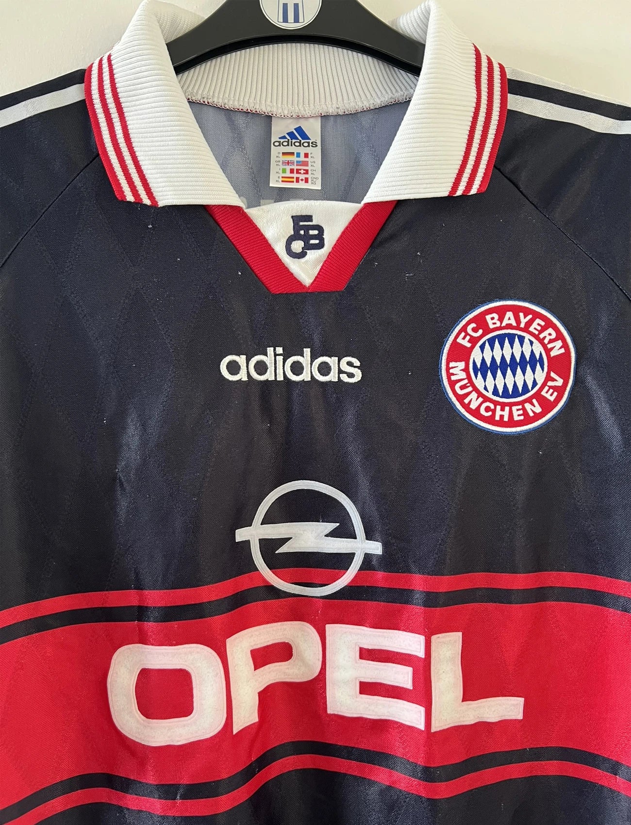 Maillot de foot vintage domicile noir et rouge du bayern munich de la saison 1997/1998. On peut retrouver l'équipementier adidas et le sponsor Opel. Il s'agit d'un maillot authentique d'époque.