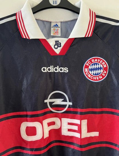 Maillot de foot vintage domicile noir et rouge du bayern munich de la saison 1997/1998. On peut retrouver l'équipementier adidas et le sponsor Opel. Il s'agit d'un maillot authentique d'époque.