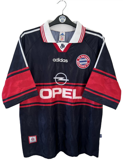 Maillot de foot vintage domicile noir et rouge du bayern munich de la saison 1997/1998. On peut retrouver l'équipementier adidas et le sponsor Opel. Il s'agit d'un maillot authentique d'époque.