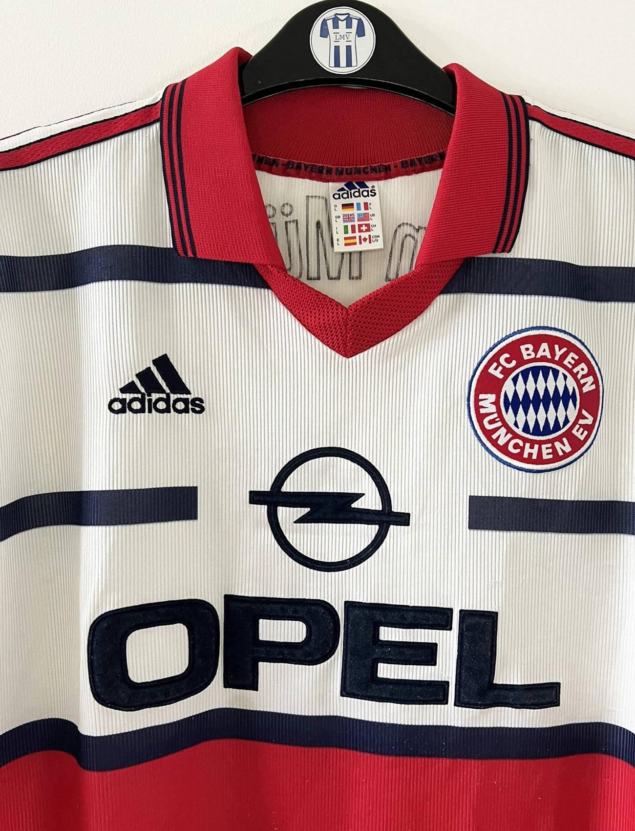 Maillot de foot vintage extérieur blanc et rouge du bayern munich de la saison 1998/1999. On peut retrouver l'équipementier Adidas et le sponsor Opel. Le maillot est floqué du numéro 3 Bixente Lizarazu. Il s'agit d'un maillot authentique d'époque.