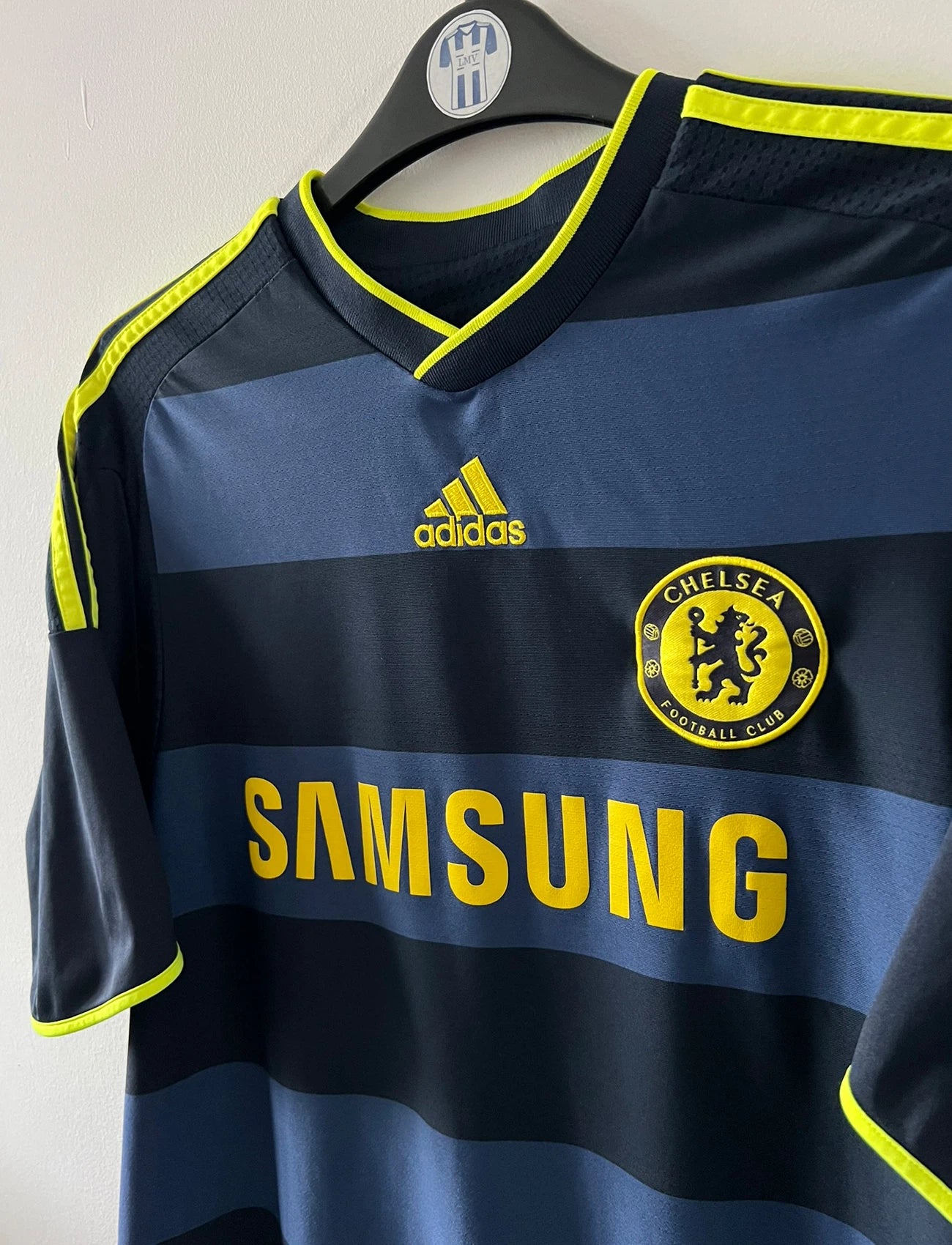 Maillot de foot vintage extérieur noir de chelsea 2009/2010. On peut retrouver l'équipementier Adidas et le sponsor Samsung. Le maillot est floqué du numéro 11 Didier Drogba. Il s'agit d'un maillot authentique d'époque.