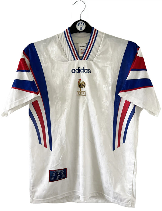 Maillot de foot vintage extérieur blanc de l'équipe de france 1996. On peut retrouver l'équipementier Adidas et le coq sans l'étoile. Il s'agit d'un maillot authentique d'époque.